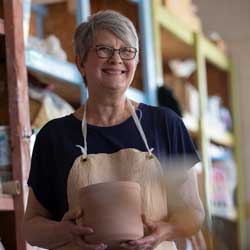 woman holding pottery inside a pottery store