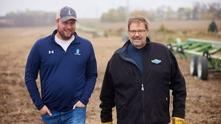 Agent and farmer walking in field