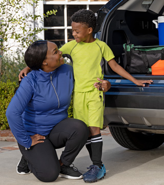 Mother getting her son ready for soccer practice