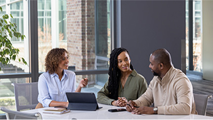 Financial professional sits at table talking with couple.