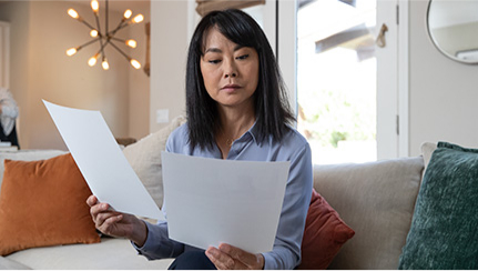 Woman looking at papers in her home.