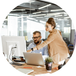 man working on computer while a co-worker points at the screen