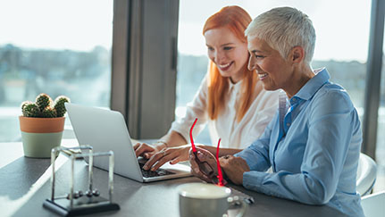 two people working at a laptop