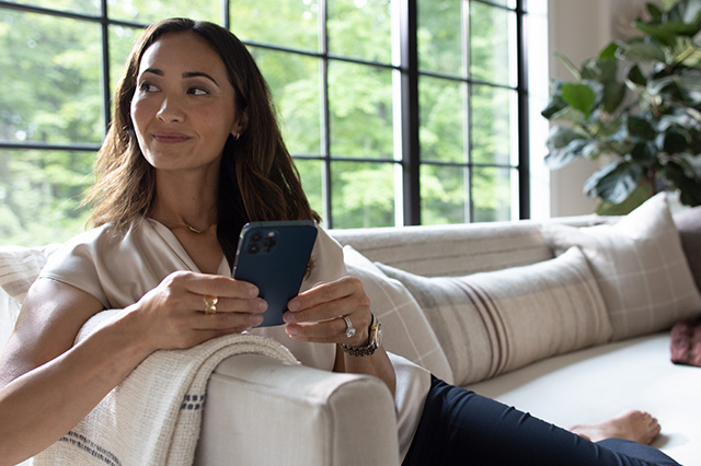 woman sitting on the couch with a laptop in the forefront