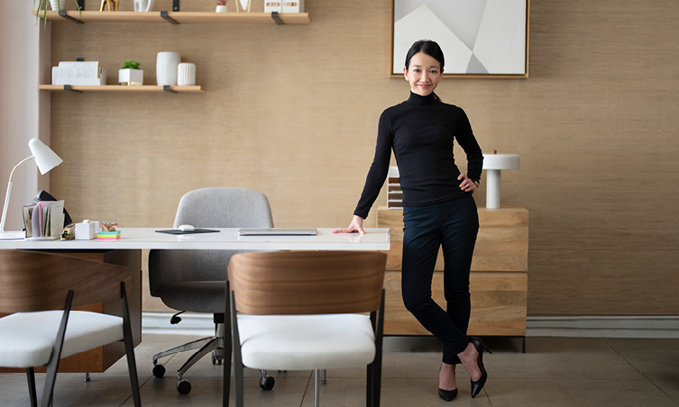 Smiling woman standing next to desk