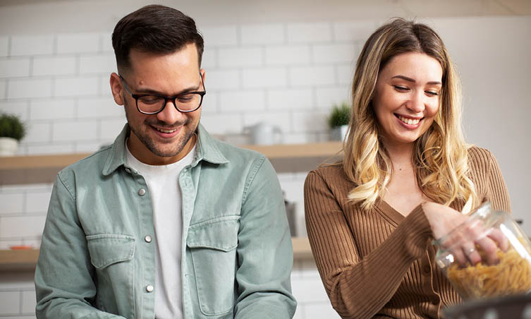 Older man and woman laughing in kitchen together